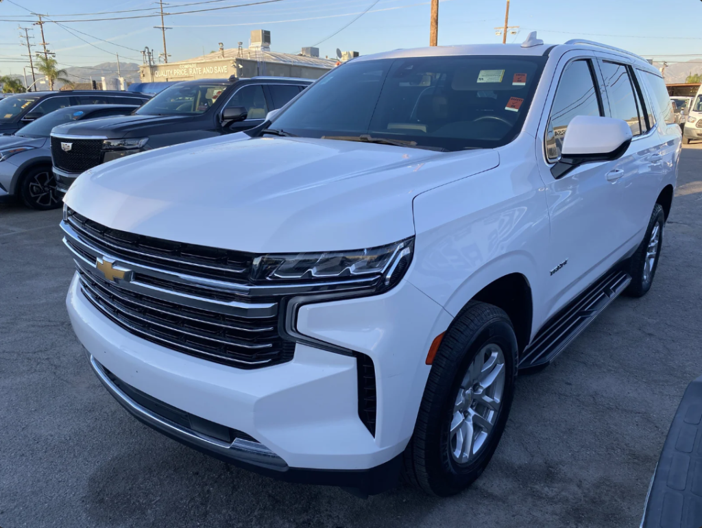 A white 2021 Chevrolet Tahoe parked in a dealerships parking lot.
